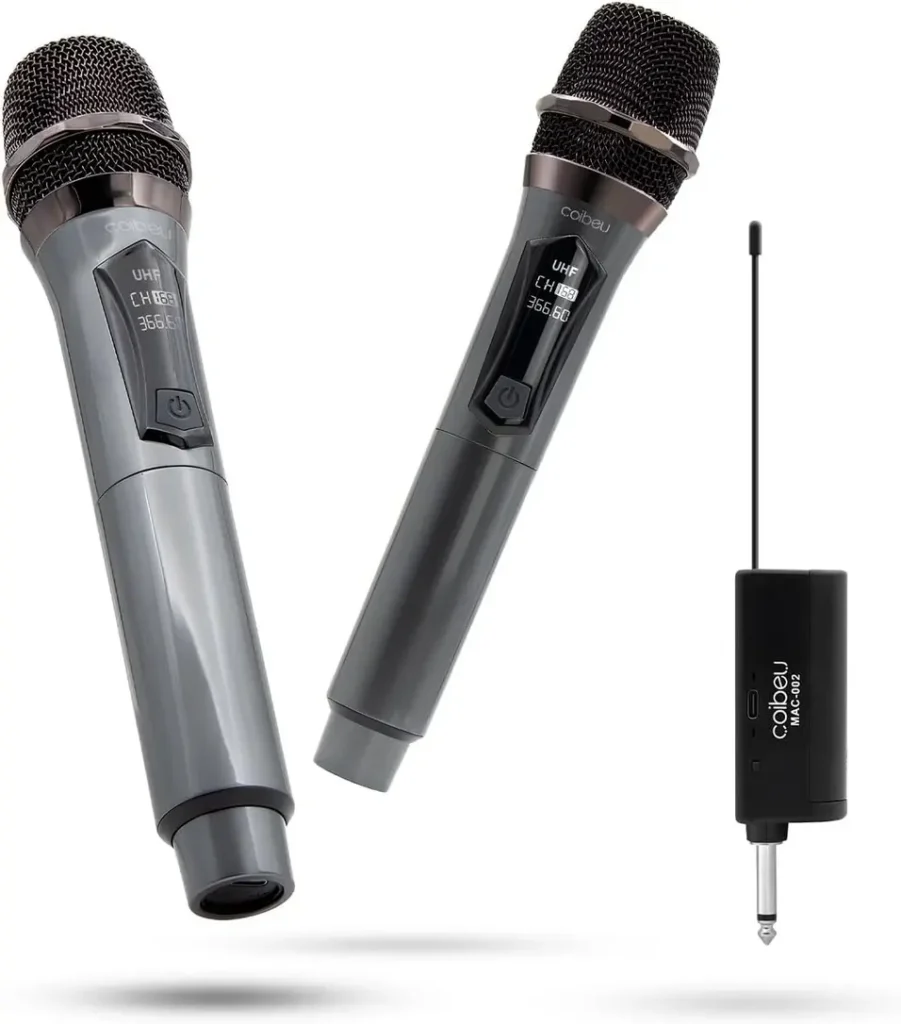 Dois microfones sem fio Coibeu MAC002 pretos com detalhes em cinza, com seus respectivos receptores P10 e cabos de carregamento, dispostos sobre um fundo branco.